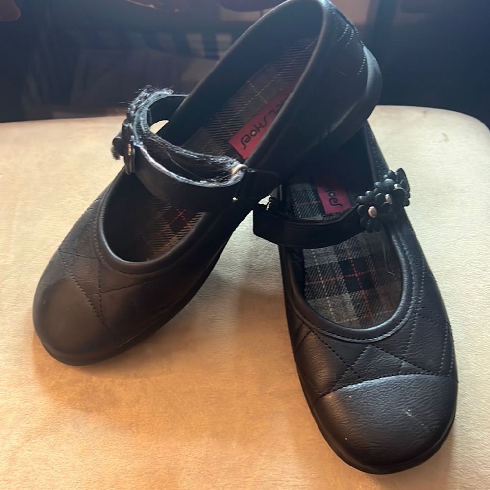 Girls black Mary Janes with cute flower detail on strap